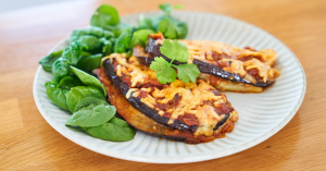 A plate of eggplant parmigiana topped with lots of fresh basil